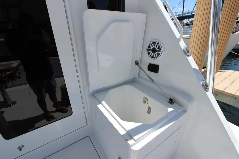 Slide: The Image of 2004 Hatteras 60 Convertible yacht sink area with open lid and speaker. - 20
