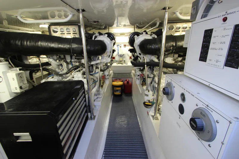 Slide: The Image of Engine room of 2004 Hatteras 60 Convertible yacht, featuring dual engines and control panels. - 23