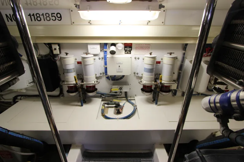 Slide: The Image of Engine room of 2004 Hatteras 60 Convertible yacht, featuring fuel filters and piping. - 26