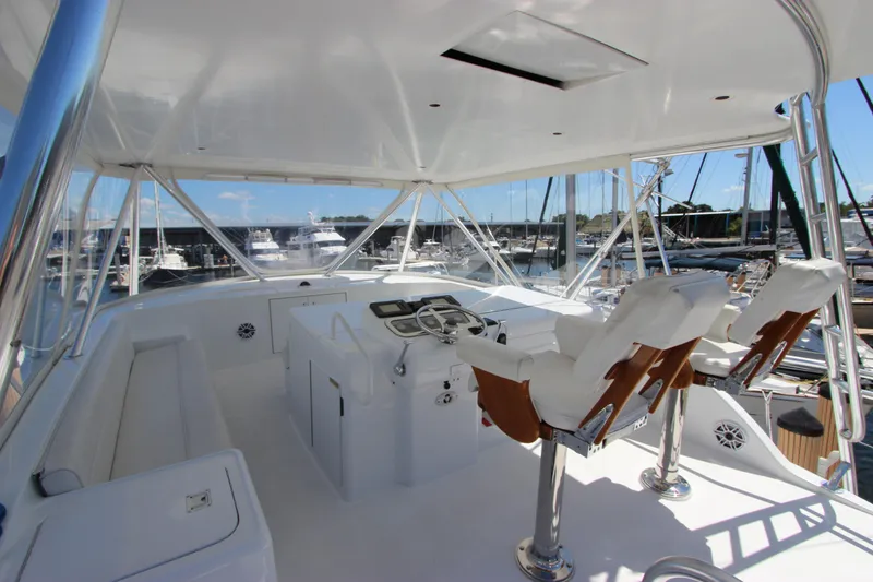 Slide: The Image of 2004 Hatteras 60 Convertible yacht bridge with helm chairs and marina view. - 35
