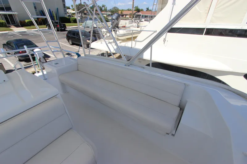 Slide: The Image of 2004 Hatteras 60 Convertible yacht with white seating area on deck. - 36