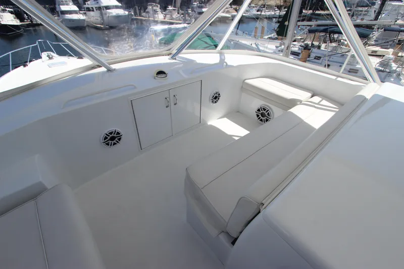 Slide: The Image of 2004 Hatteras 60 Convertible yacht interior with white seating and storage, docked at marina. - 37