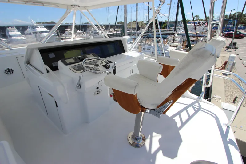 Slide: The Image of Helm station of 2004 Hatteras 60 Convertible yacht with captain's chair and navigation controls. - 39