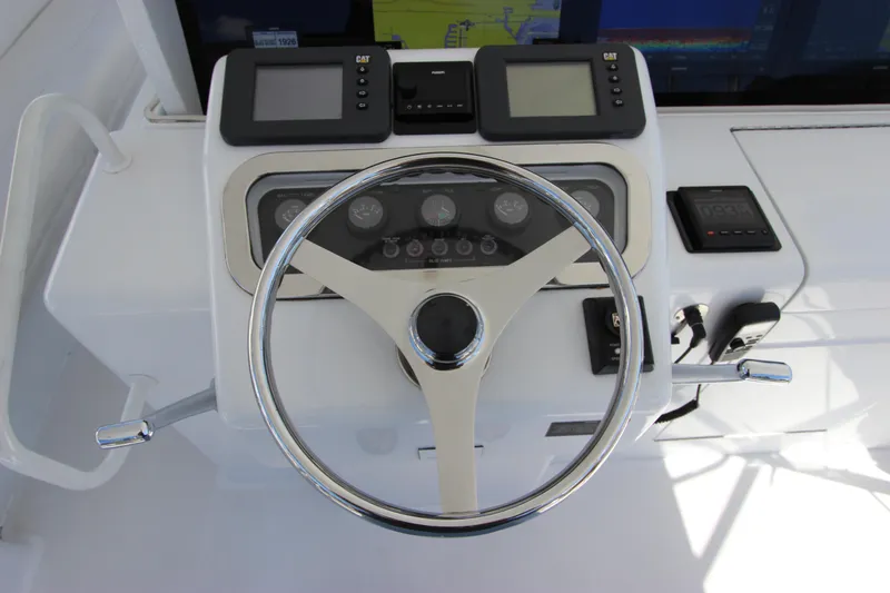 Slide: The Image of 2004 Hatteras 60 Convertible yacht helm with steering wheel and navigation controls. - 41