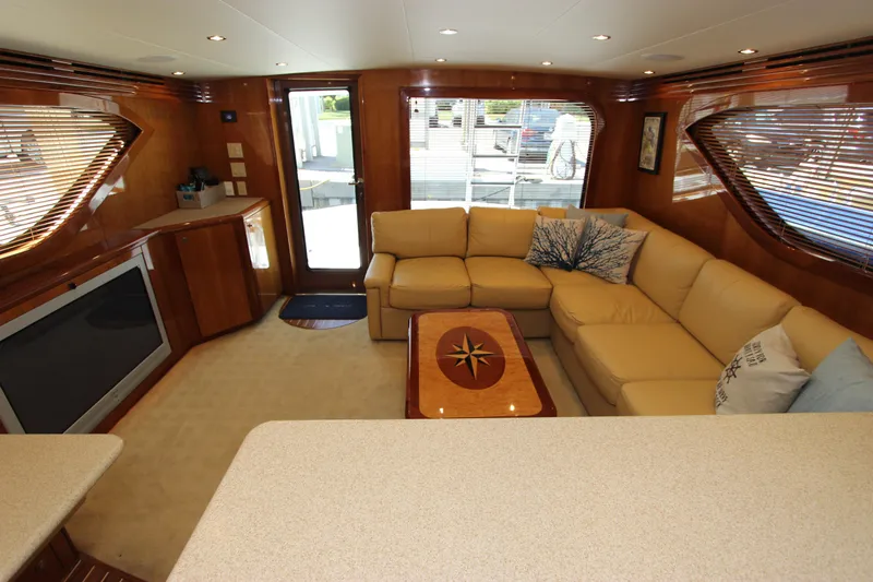 Slide: The Image of Luxurious interior of 2004 Hatteras 60 Convertible yacht with beige seating and wooden accents. - 48