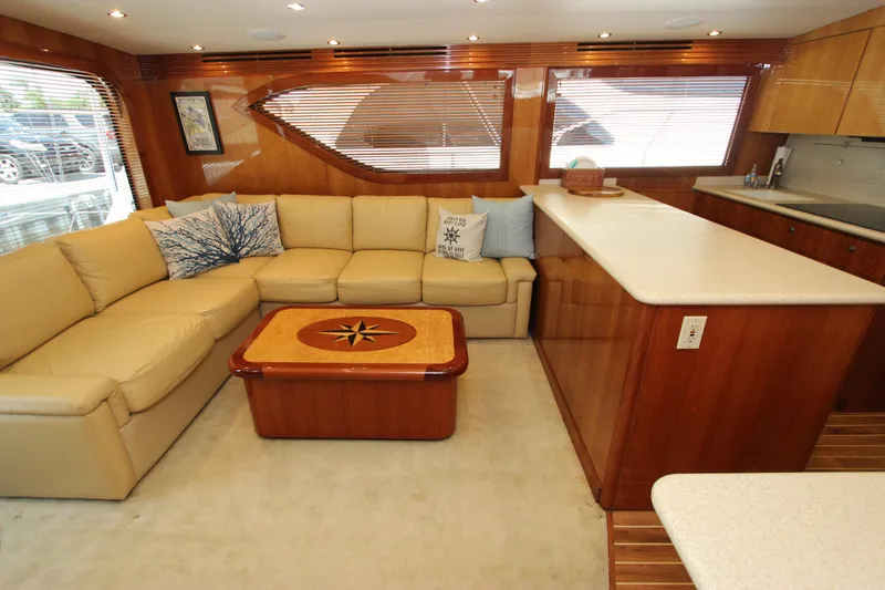 Slide: The Image of Luxurious interior of 2004 Hatteras 60 Convertible yacht with beige sofa and wooden accents. - 49