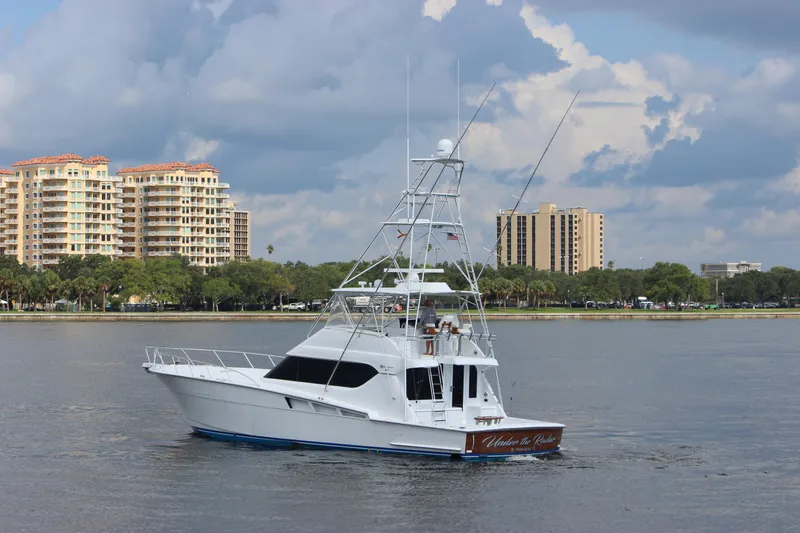 Slide: The Image of 2004 Hatteras 60 Convertible yacht cruising near urban waterfront buildings. - 5