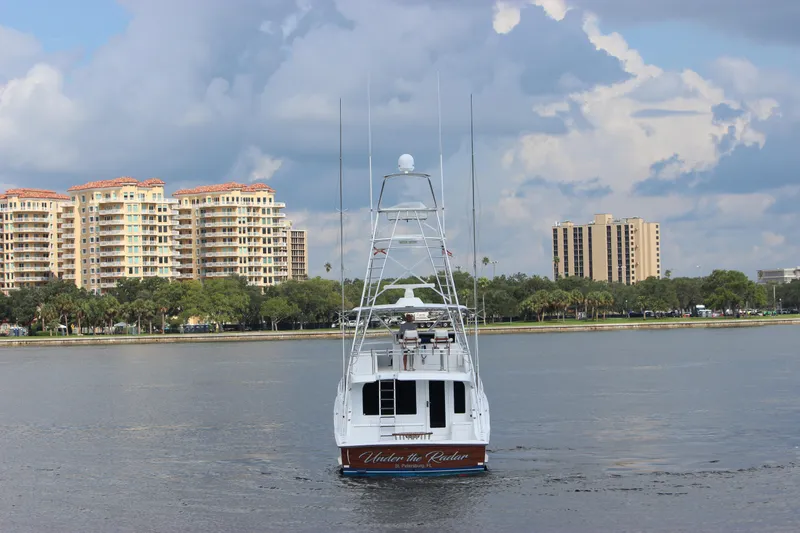 Slide: The Image of 2004 Hatteras 60 Convertible yacht on water with cityscape background. - 7