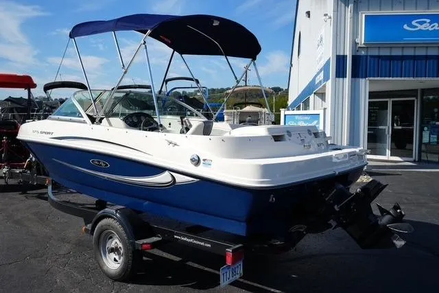 Slide: The Image of 2008 Sea Ray 175 Sport boat with blue canopy on trailer, parked outside dealership. - 5