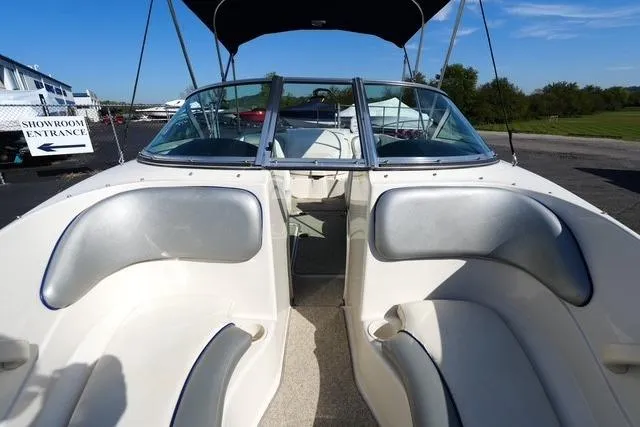 Slide: The Image of 2008 Sea Ray 175 Sport boat interior with seating and windshield, parked outdoors. - 8