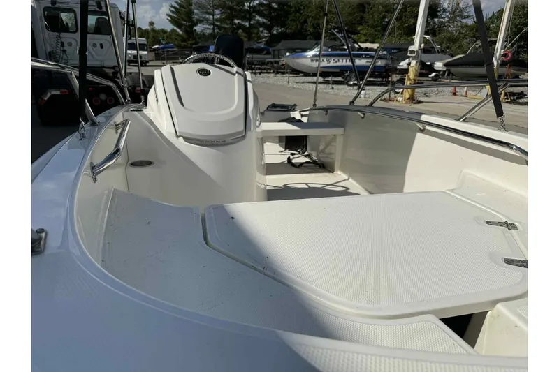 Slide: The Image of 2024 Boston Whaler 130 Super Sport boat interior, featuring seating and steering console. - 10