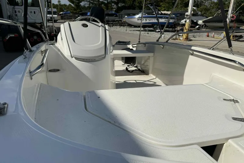 Slide: The Image of 2024 Boston Whaler 130 Super Sport boat interior, featuring sleek white design and spacious seating. - 11