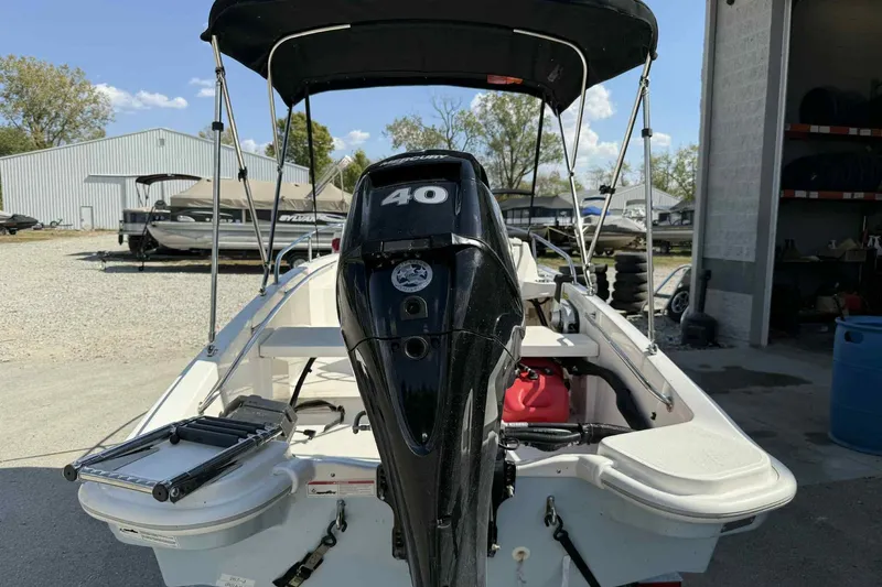 Slide: The Image of 2024 Boston Whaler 130 Super Sport boat with 40 HP engine, parked outdoors. - 3