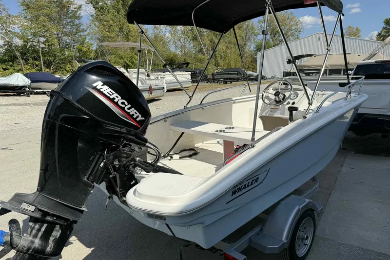 Slide: The Image of 2024 Boston Whaler 130 Super Sport boat with Mercury engine, parked on a trailer. - 4