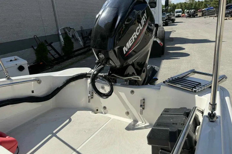 Slide: The Image of 2024 Boston Whaler 130 Super Sport with Mercury outboard motor in a parking area. - 9