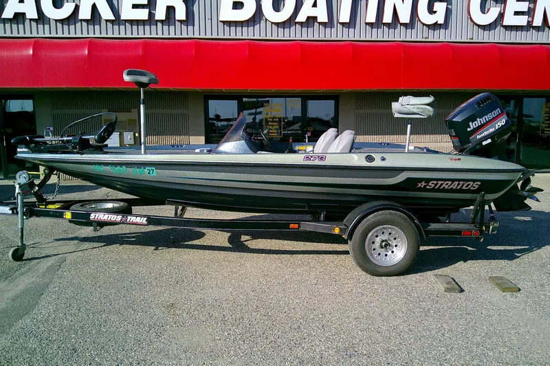 Slide: The Image of 1998 Stratos 273 V fishing boat with Johnson 150 motor on trailer, outside boating center. - 0