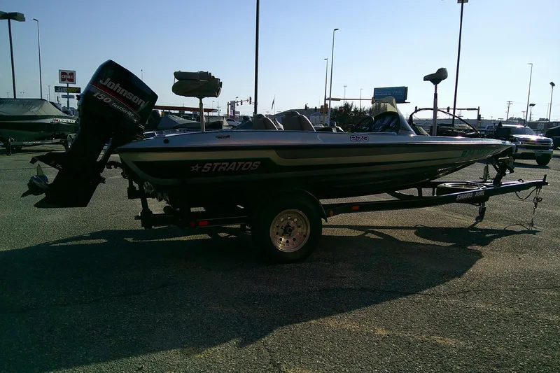 Slide: The Image of 1998 Stratos 273 V boat with Johnson motor on trailer in parking lot. - 13