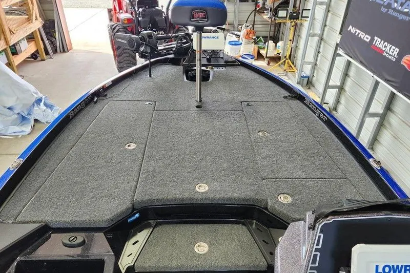 Slide: The Image of 2025 Ranger Z520 boat interior with carpeted deck in a garage setting. - 10