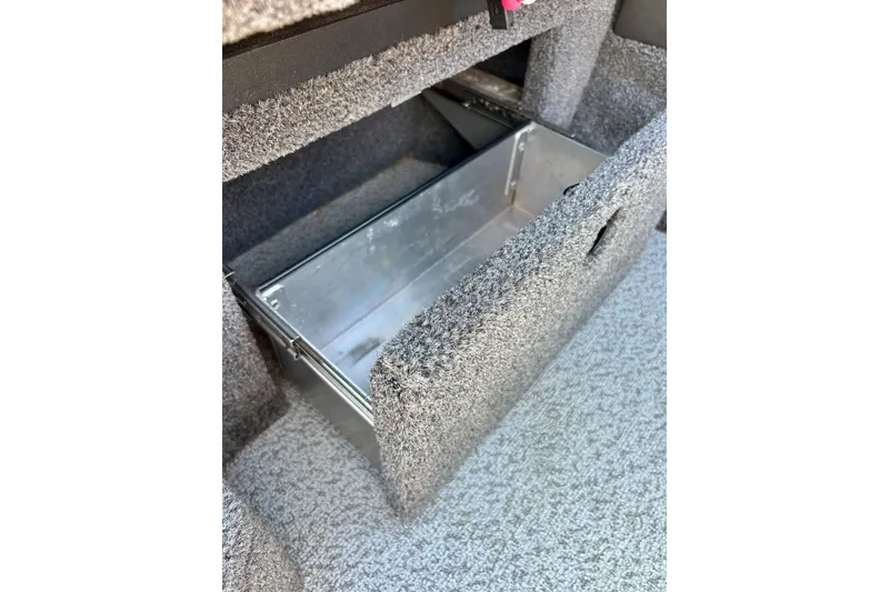 Slide: The Image of 2021 Lund 1875 Crossover XS storage compartment with carpeted interior and metal box. - 16