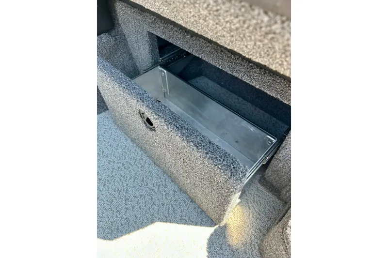 Slide: The Image of 2021 Lund 1875 Crossover XS boat storage compartment with open lid, carpeted interior. - 18