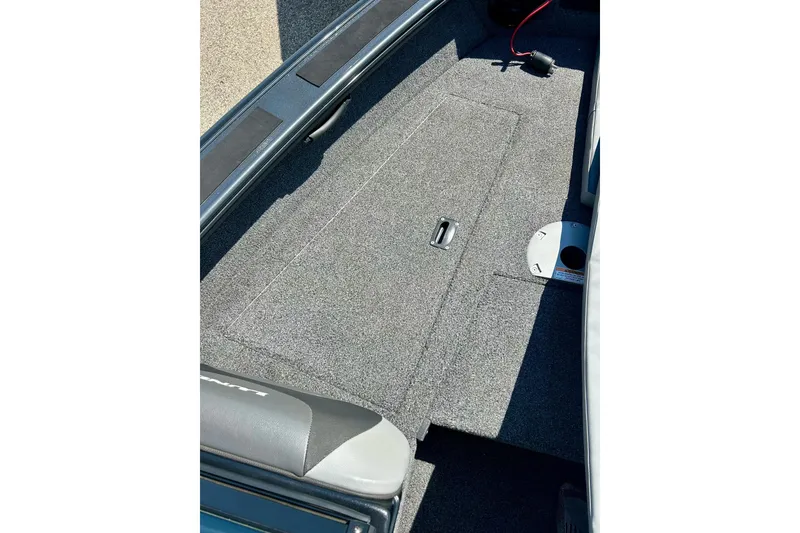 Slide: The Image of 2021 Lund 1875 Crossover XS boat interior with carpeted deck and storage compartment. - 21