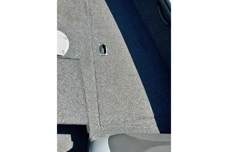 Slide: The Image of 2021 Lund 1875 Crossover XS boat interior with gray carpet and storage compartment. - 26