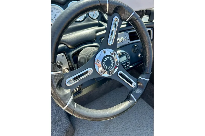 Slide: The Image of Steering wheel of 2021 Lund 1875 Crossover XS boat, featuring sleek design and controls. - 32
