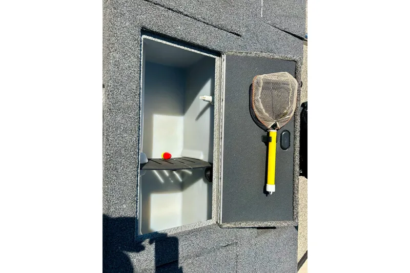 Slide: The Image of 2021 Lund 1875 Crossover XS boat storage compartment with fishing net and accessories. - 34