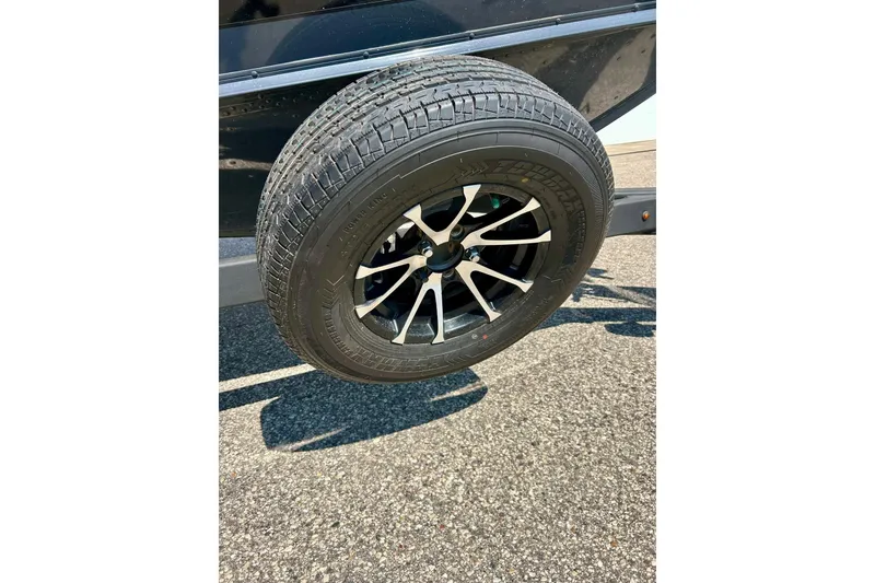 Slide: The Image of 2021 Lund 1875 Crossover XS trailer wheel on asphalt surface. - 4