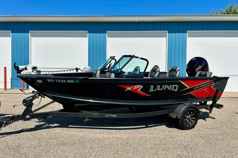Slide: The Image of 2021 Lund 1875 Crossover XS boat on trailer, parked outside blue building. - 45