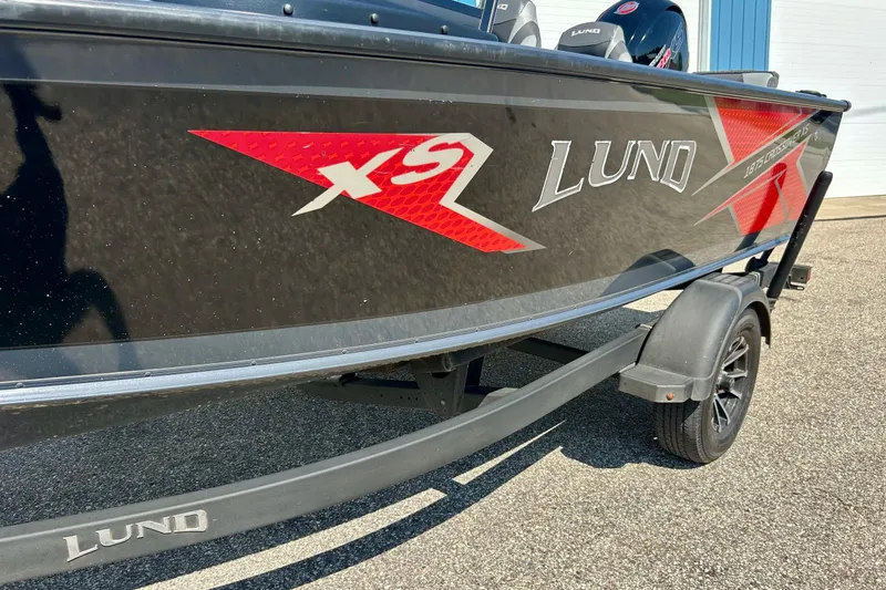 Slide: The Image of 2021 Lund 1875 Crossover XS boat on trailer, black with red accents. - 46