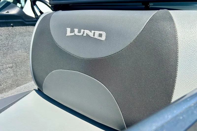 Slide: The Image of 2021 Lund 1875 Crossover XS boat seat with logo, featuring gray and black upholstery. - 55