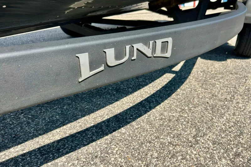 Slide: The Image of Close-up of 2021 Lund 1875 Crossover XS boat trailer logo on pavement. - 62
