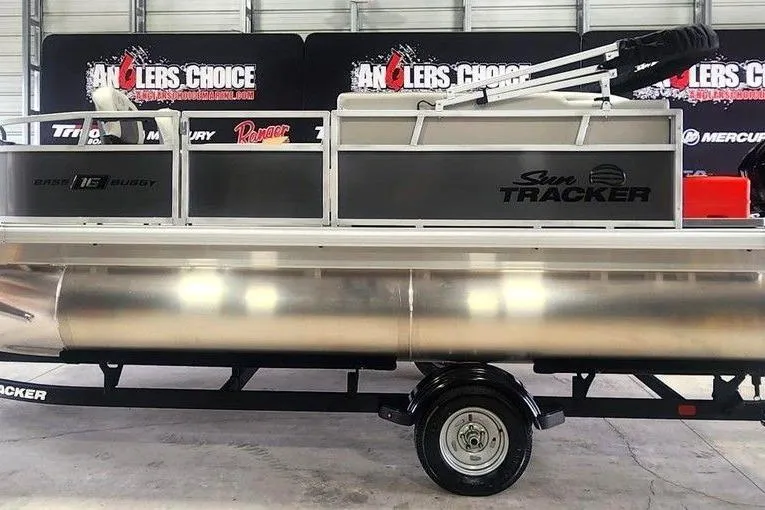 The Image of 2026 Sun Tracker Bass Buggy 16 XL Select pontoon boat on trailer in showroom. - 0