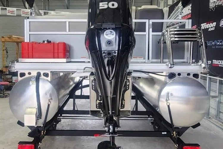 Slide: The Image of 2026 Sun Tracker Bass Buggy 16 XL Select pontoon boat with 50 HP engine in a garage. - 3