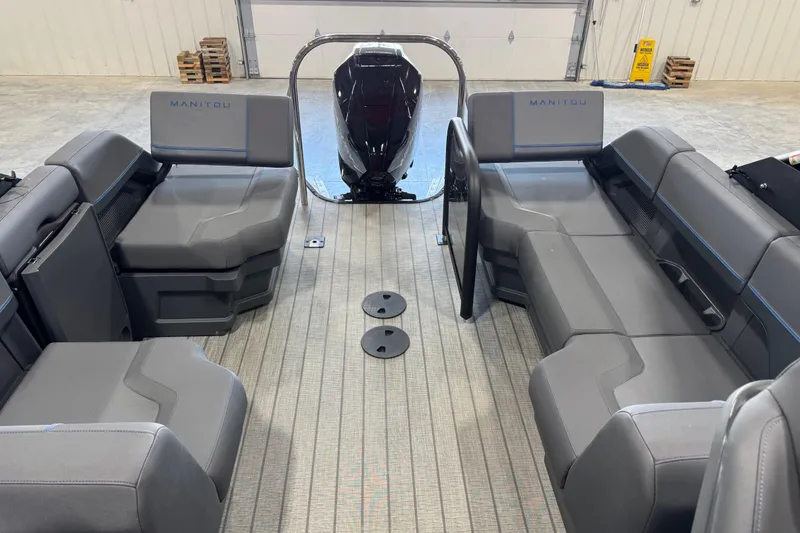 Slide: The Image of Interior view of 2025 Manitou 26 Explore pontoon boat with modern seating and motor. - 10