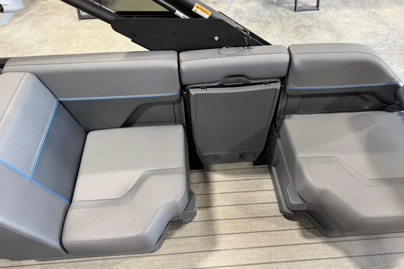 Slide: The Image of 2025 Manitou 26 Explore boat interior seating with modern gray upholstery and blue accents. - 13