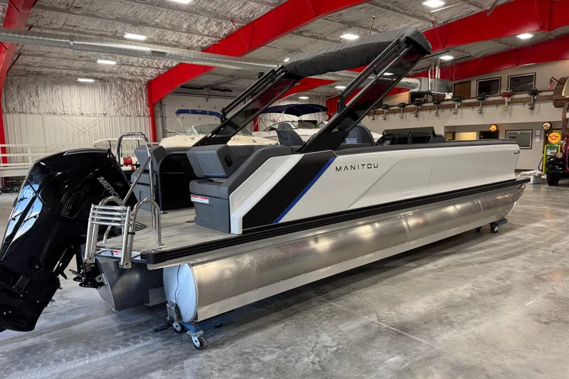 Slide: The Image of 2025 Manitou 26 Explore pontoon boat in showroom, featuring sleek design and modern amenities. - 5