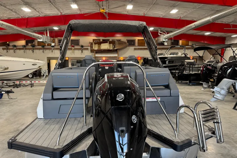 Slide: The Image of 2025 Manitou 26 Explore boat in showroom, featuring sleek design and powerful engine. - 6