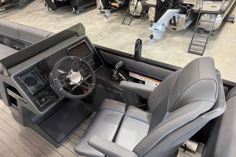 Slide: The Image of 2025 Manitou 26 Explore boat interior with steering wheel and captain's chair. - 7