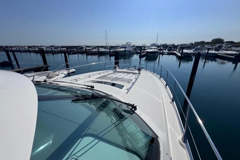 Slide: The Image of 2011 Sea Ray 540 Sundancer yacht docked in a marina under clear blue skies. - 10