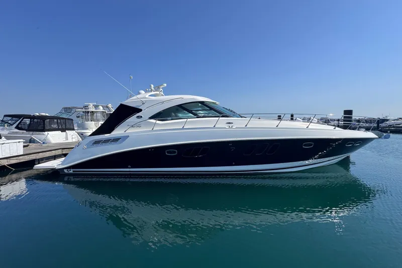 Slide: The Image of 2011 Sea Ray 540 Sundancer yacht docked in a marina under clear blue skies. - 2