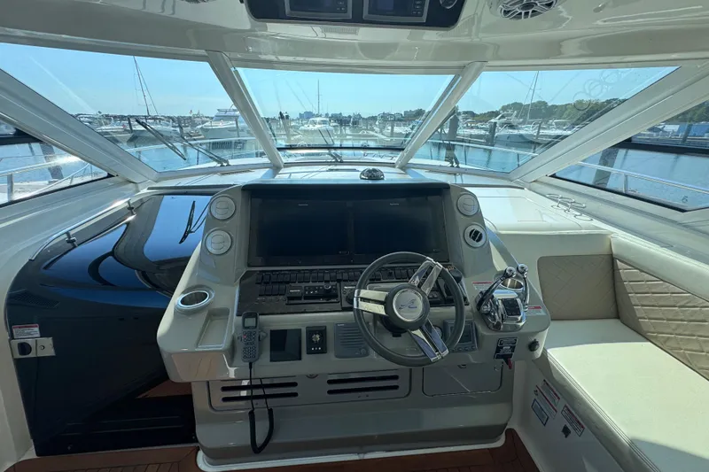 Slide: The Image of 2011 Sea Ray 540 Sundancer helm with steering wheel and navigation controls. - 29