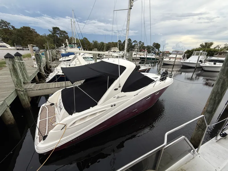 The Image of 2006 Sea Ray 290 Sundancer docked at marina, featuring sleek design and black canopy. - 0