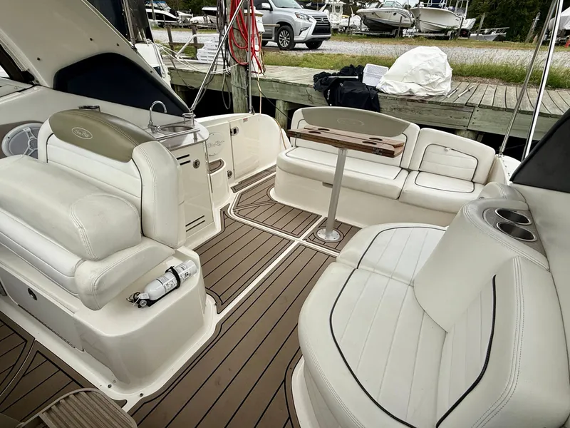 Slide: The Image of 2006 Sea Ray 290 Sundancer boat interior with white seating and wood accents. - 10