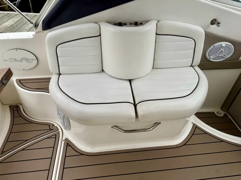 Slide: The Image of 2006 Sea Ray 290 Sundancer boat seating with white cushions and cup holders. - 11