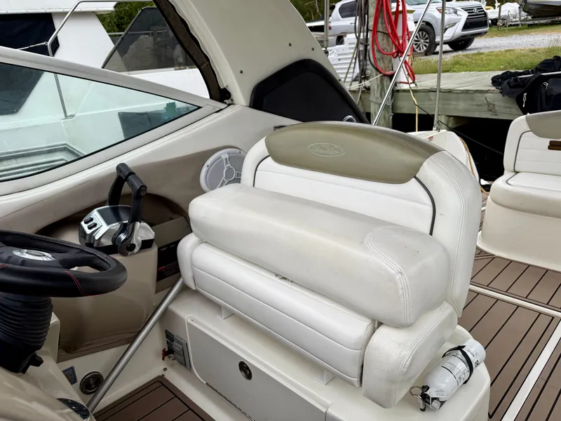 Slide: The Image of 2006 Sea Ray 290 Sundancer helm with white seating and steering wheel. - 14