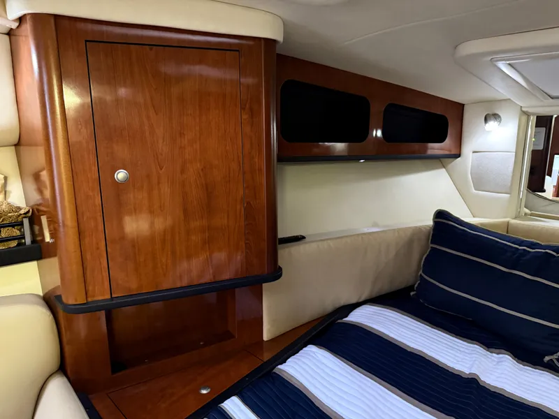 Slide: The Image of Interior of 2006 Sea Ray 290 Sundancer with wood cabinetry and cozy bedding. - 18