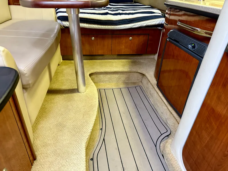 Slide: The Image of Interior of 2006 Sea Ray 290 Sundancer with seating, table, and wood cabinetry. - 19