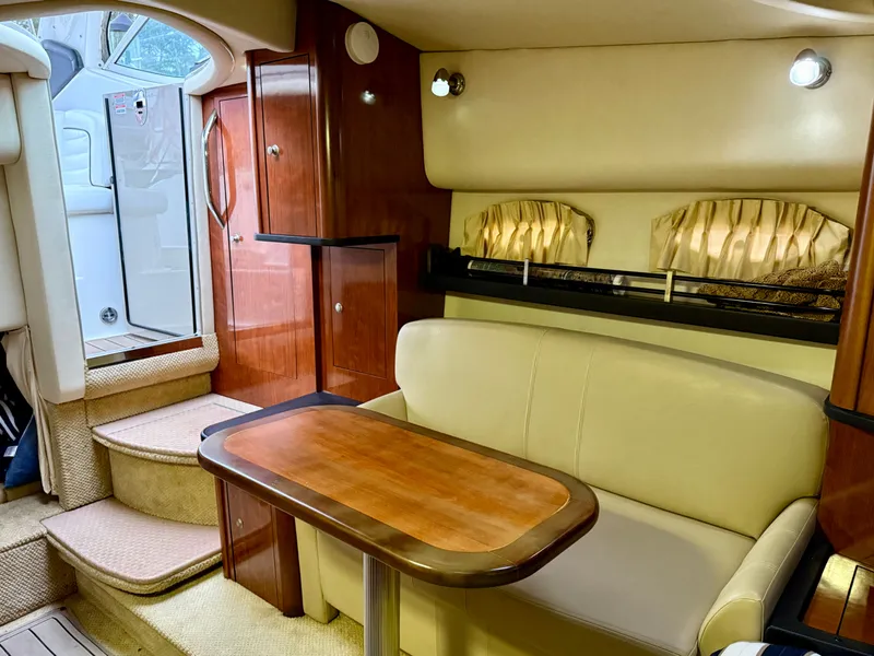 Slide: The Image of Interior of 2006 Sea Ray 290 Sundancer with cozy seating and wooden table. - 20